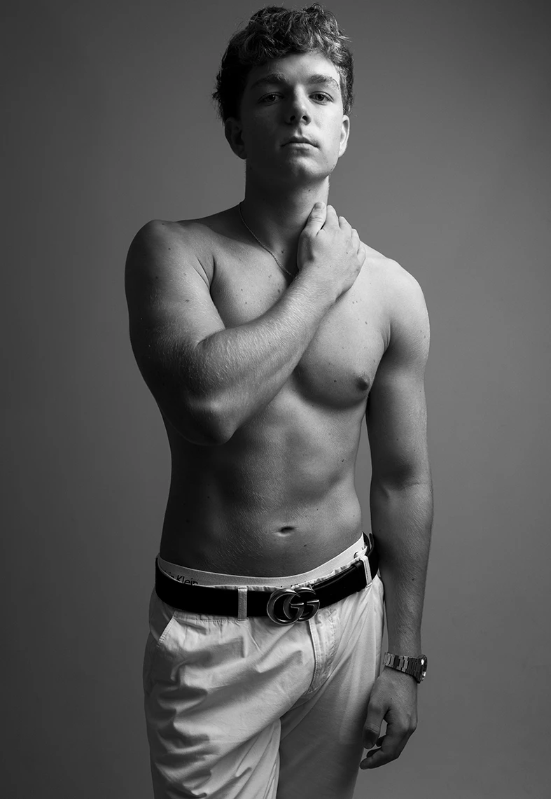 Shirtless male model in black and white with partial profile pose.