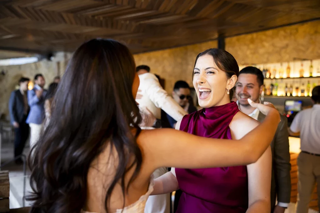 Abrazo entre amigas durante una boda de varios días en Mallorca.