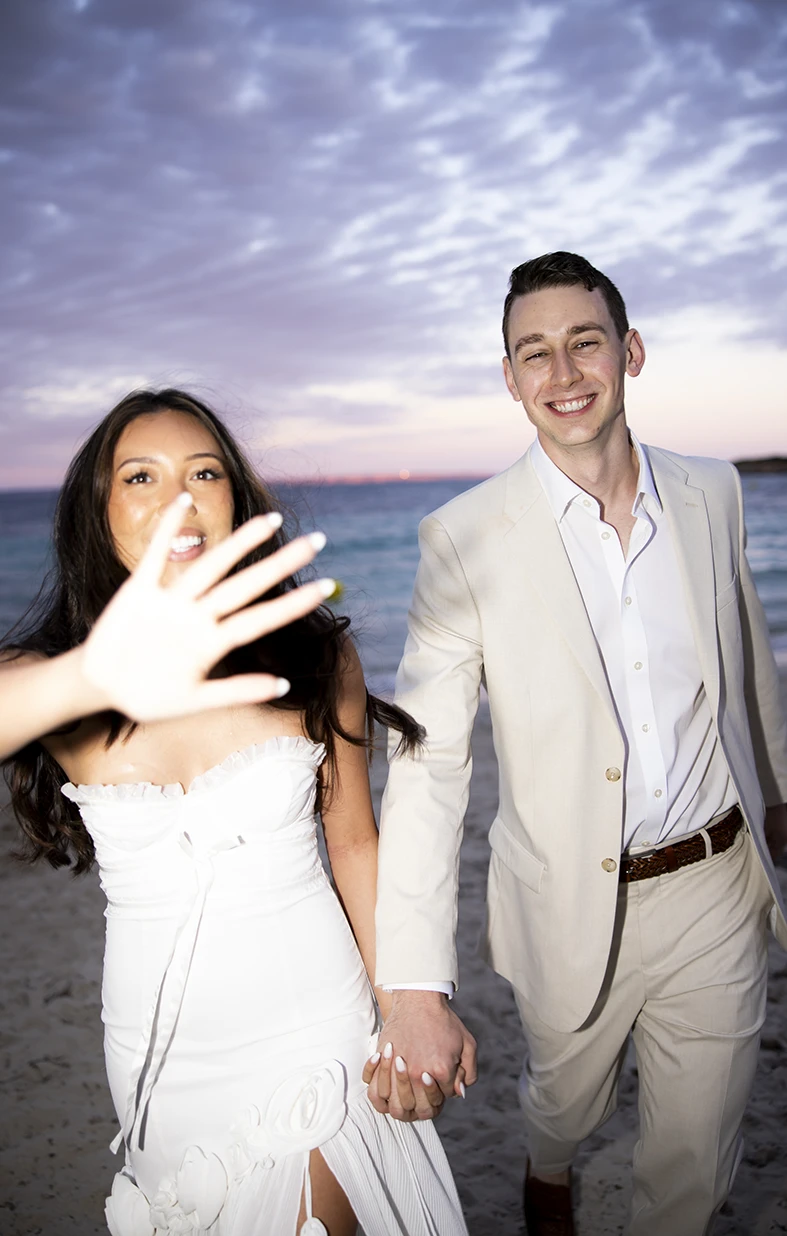 Novios riendo en la playa durante su boda de varios días en Mallorca.