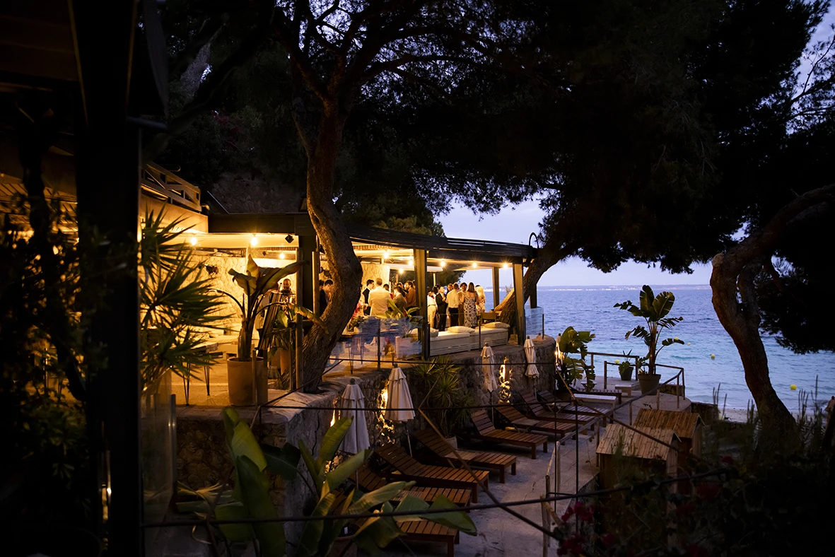 Terraza iluminada durante una boda de varios días en Mallorca al atardecer.