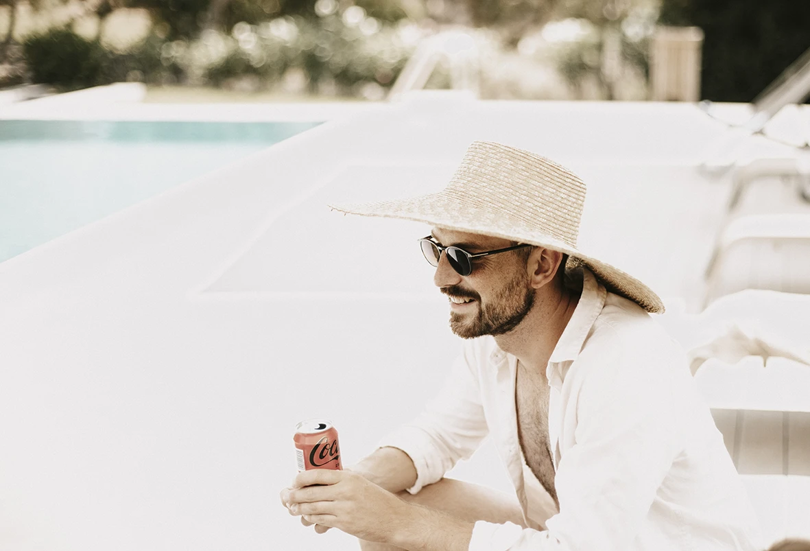 Invitado relajado con sombrero disfrutando del brunch en una boda de varios días en Mallorca.