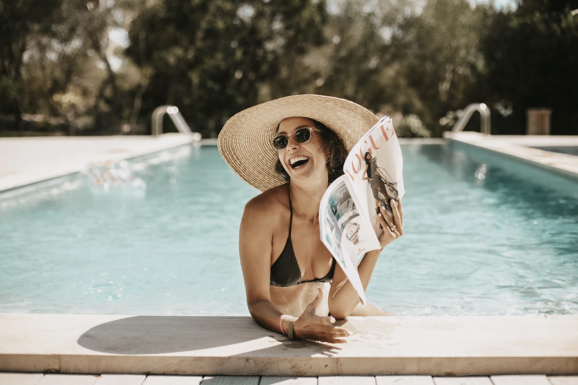 Invitada riendo en la piscina durante una boda de varios días en Mallorca.