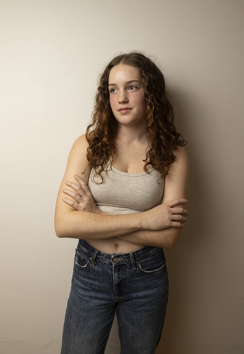 young model leaning on a warm wall with natural expression