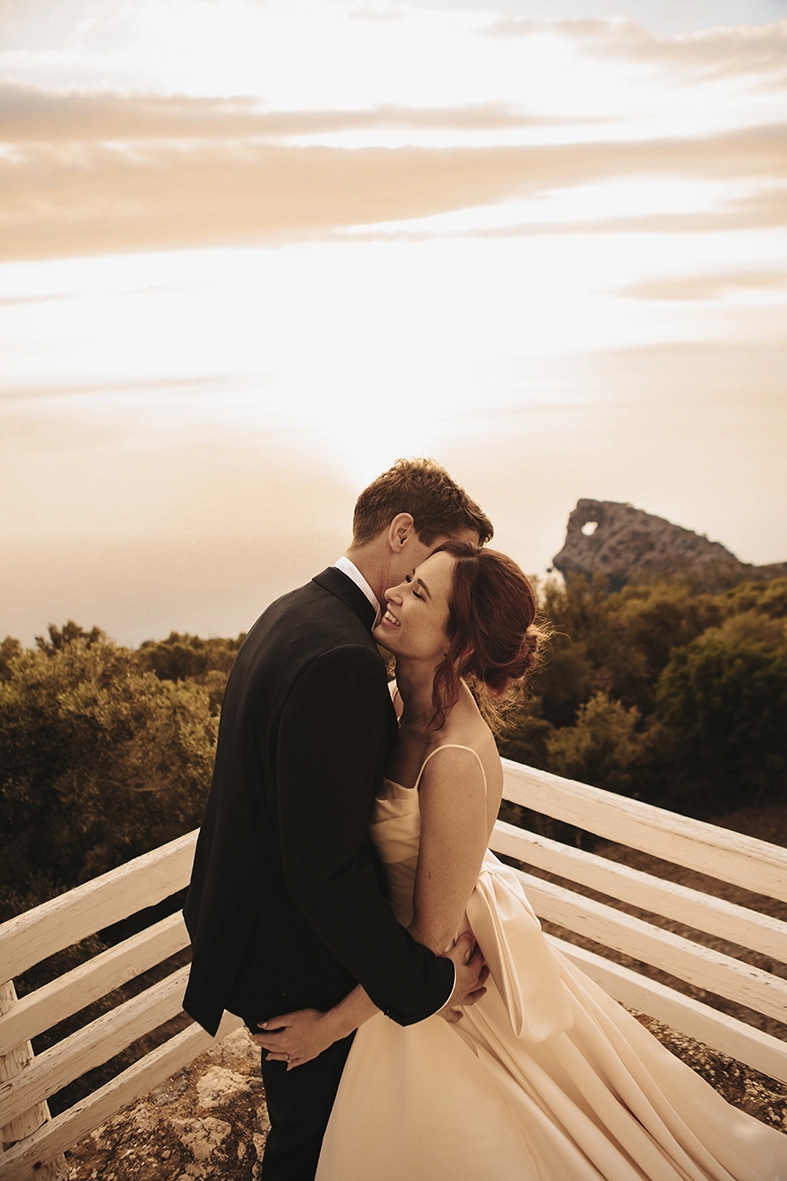 novios abrazándose al atardecer en Son Marroig Mallorca con vistas al mar