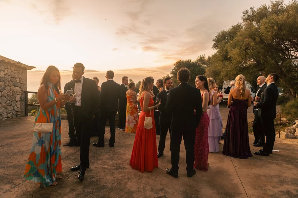 Invitados disfrutando del cocktail al atardecer durante una boda elegante en Mallorca, fotografía realizada por Inma del Valle.