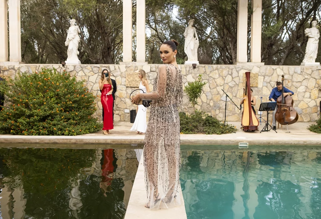 Invitada elegante junto a la piscina durante una boda de lujo en Mallorca, fotografía realizada por Inma del Valle.