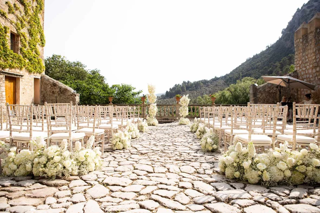 Pasillo floral para ceremonia de una boda destino de lujo Mallorca en una finca rodeada de montañas, fotografía realizada por Inma del Valle.