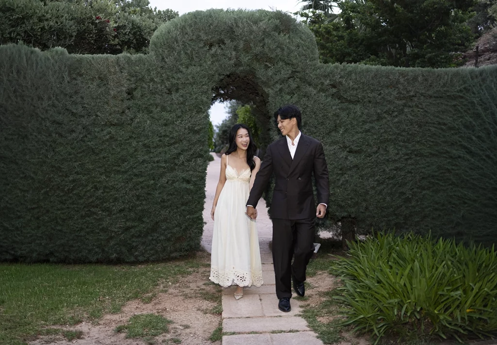 Pareja elegante caminando por los jardines durante una compromiso de lujo en Belmond La Residencia Deià