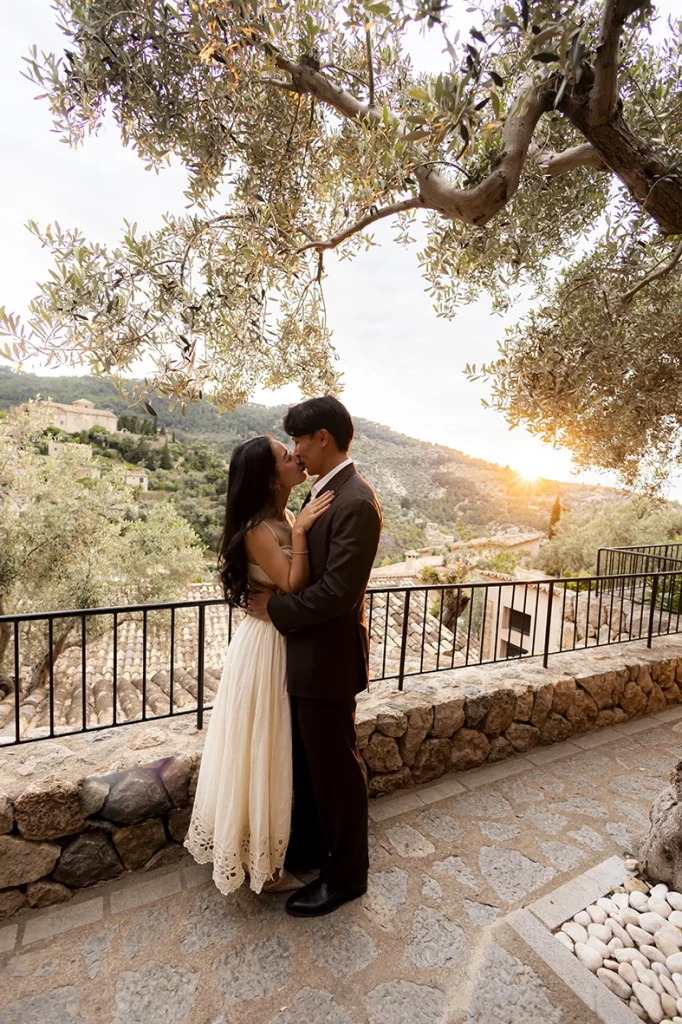 Beso romántico al atardecer durante un compromiso de lujo en Belmond La Residencia Deià
