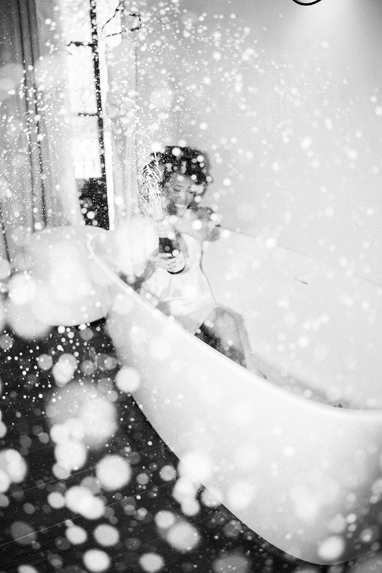 bride celebrating with champagne during wedding in Mallorca black and white
