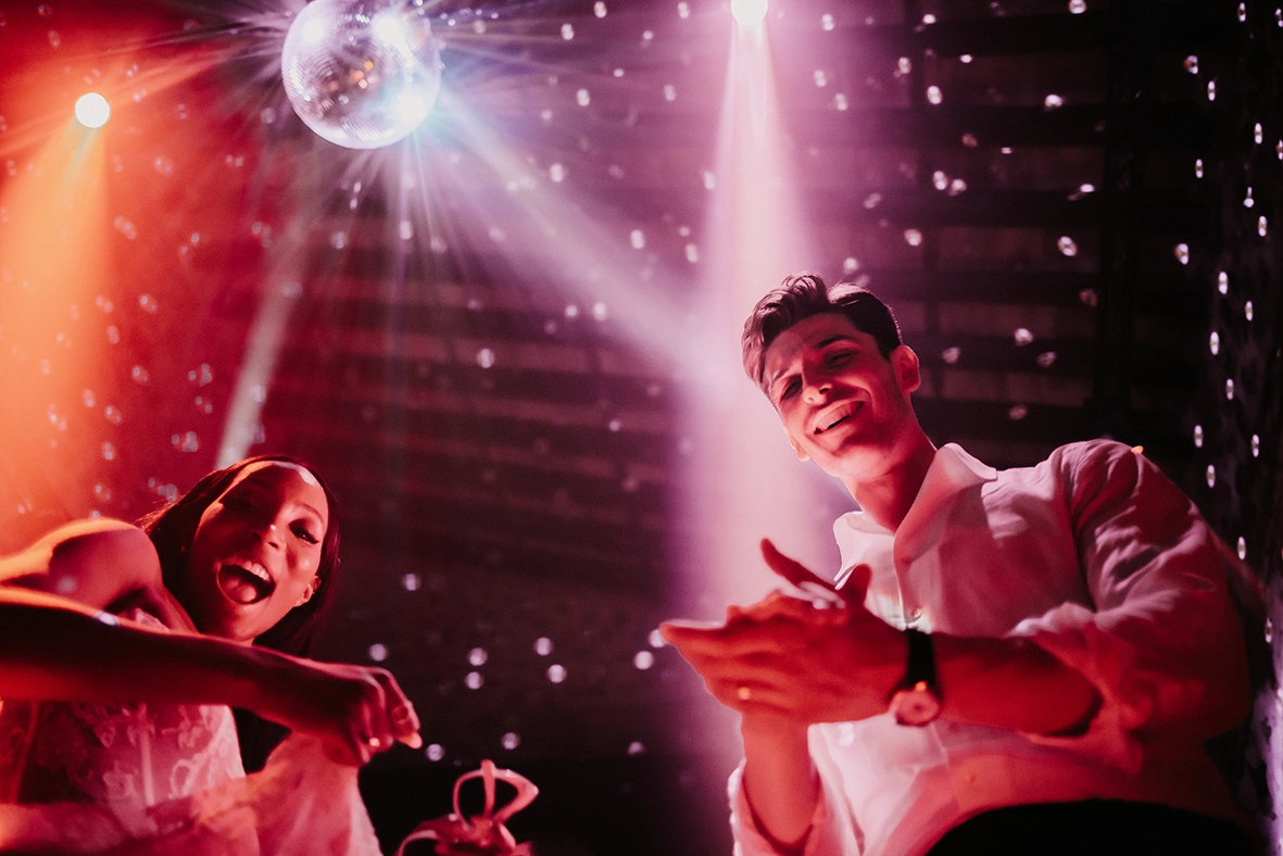 novios disfrutando de la fiesta durante boda en Mallorca bajo luces de discoteca