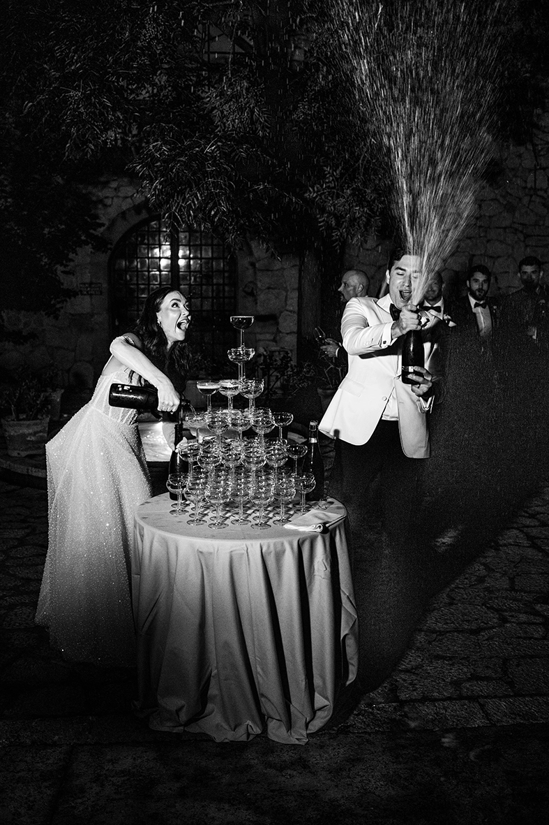 novios celebrando con champán durante boda en Mallorca en blanco y negro