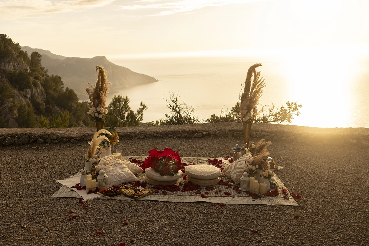 Decoración romántica de lujo para una pedida de mano sorpresa en Mallorca con flores, velas y vistas al Mediterráneo al atardecer, fotografiada por Inma del Valle.