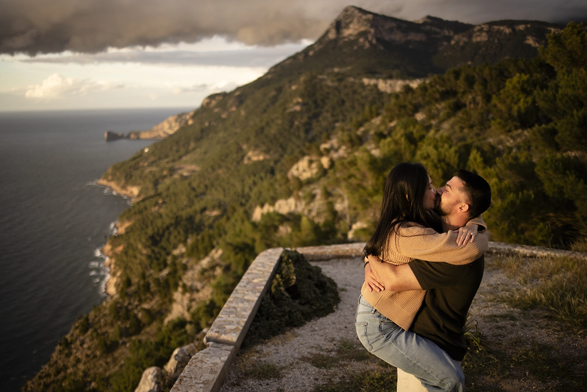 Couple kissing with mountain and sea views in Mallorca photographed by Inma del Valle, Mallorca cliff proposal photographer