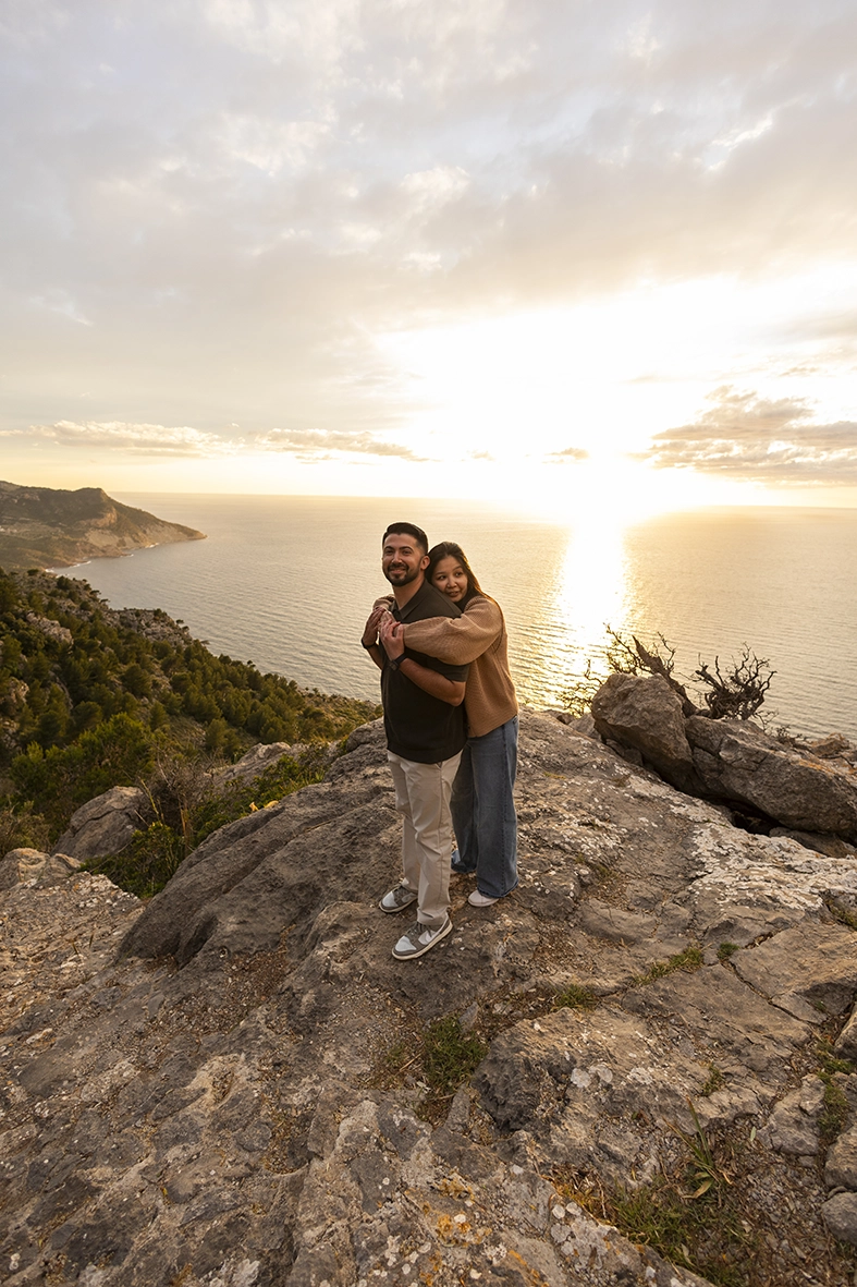 Couple embracing on a cliff in Mallorca during sunset photographed by Inma del Valle, Mallorca cliff proposal photographer
