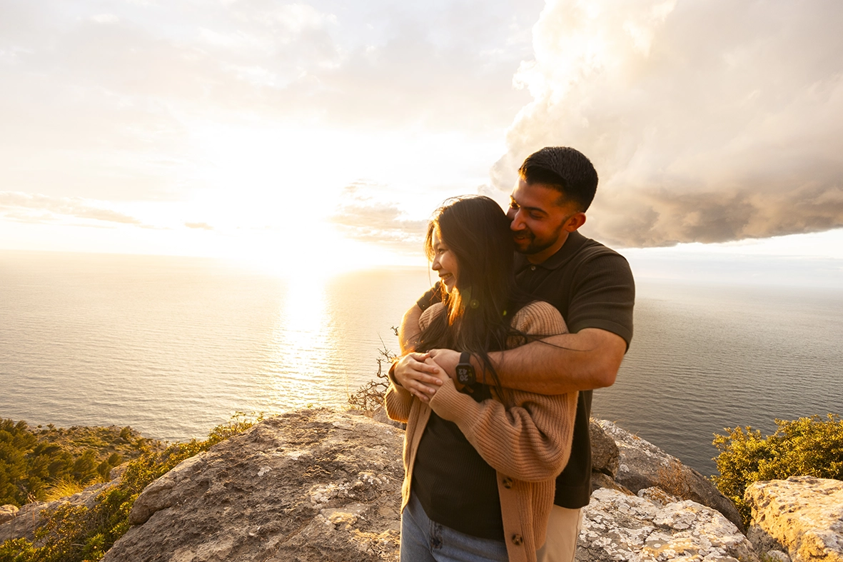 Romantic embrace during a sunset proposal session in Mallorca photographed by Inma del Valle, Mallorca cliff proposal photographer