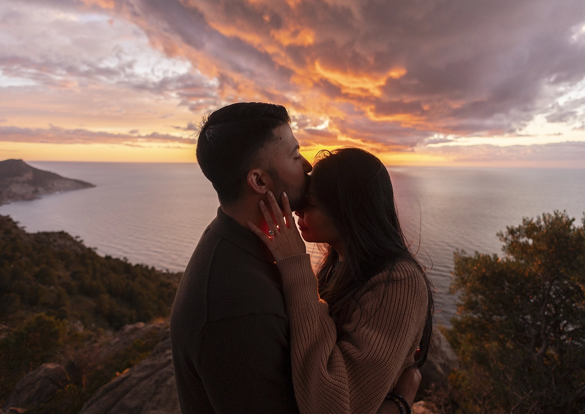 Beso romántico durante una pedida en acantilado Mallorca fotografiada por Inma del Valle
