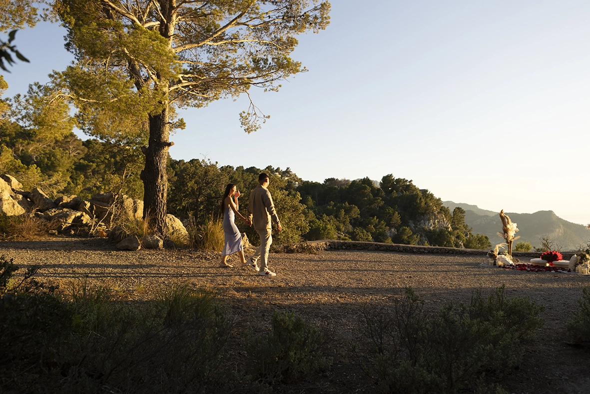 David y Katie caminando de la mano hacia el romántico montaje preparado para su propuesta de matrimonio al atardecer en Mallorca.