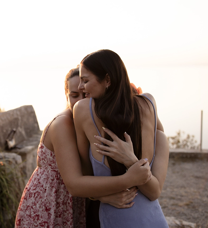 Katie abraza emocionada a una de sus amigas después de la propuesta de matrimonio al atardecer en Mallorca.
