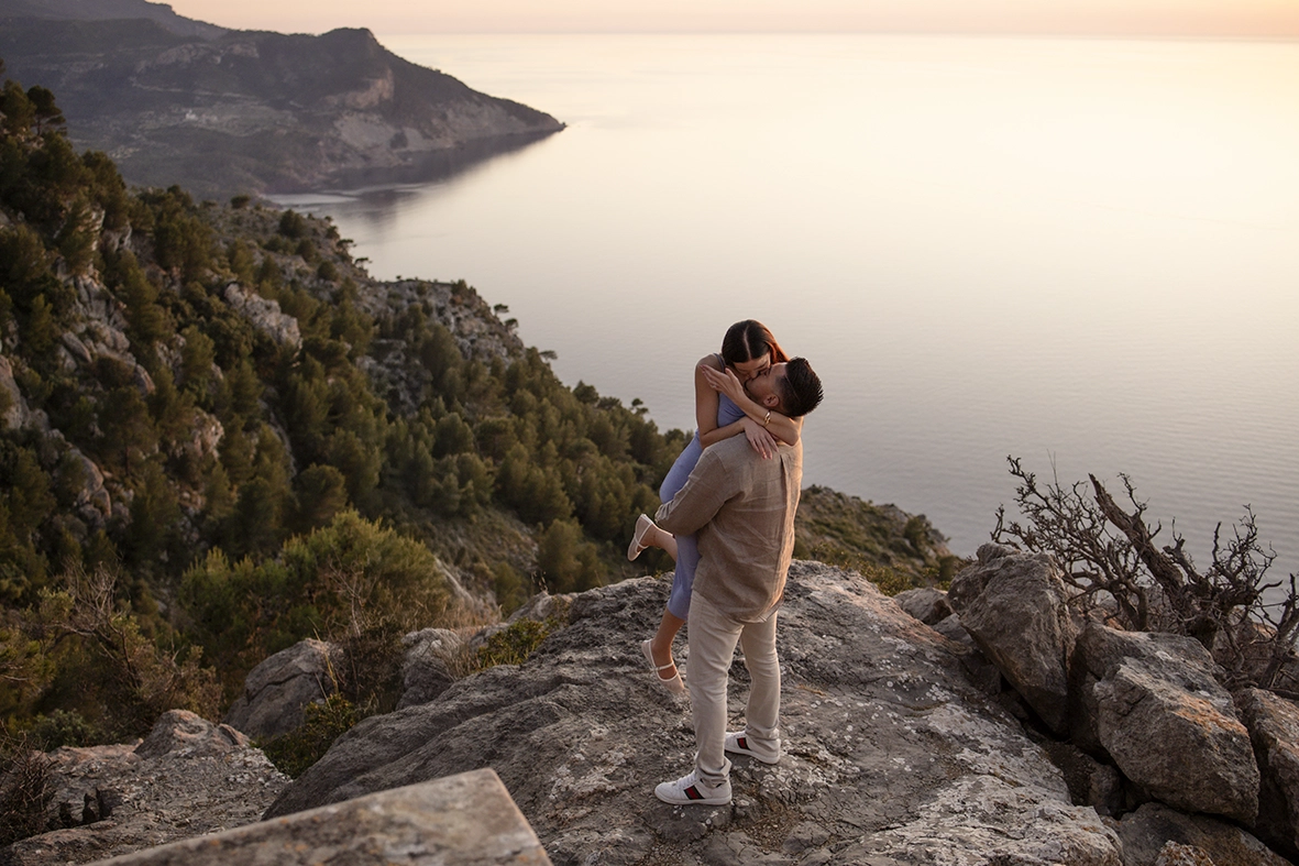 David holding Katie in his arms during a couple session after their private proposal in Mallorca