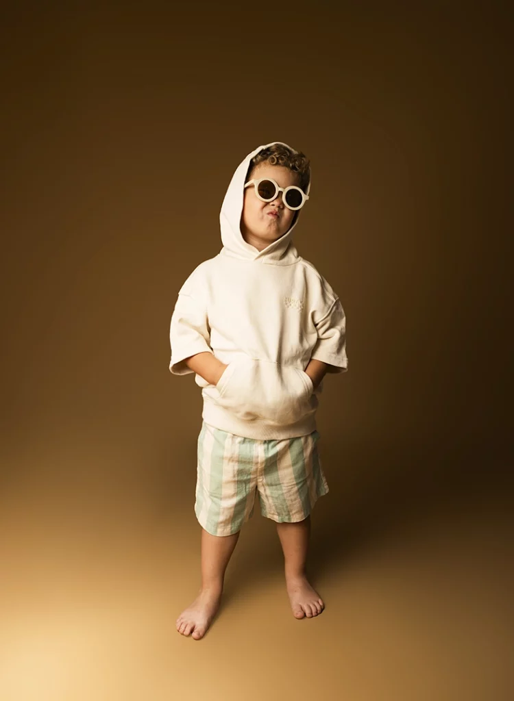 Child model Mallorca wearing a hoodie and sunglasses during a studio photoshoot by Inma del Valle.