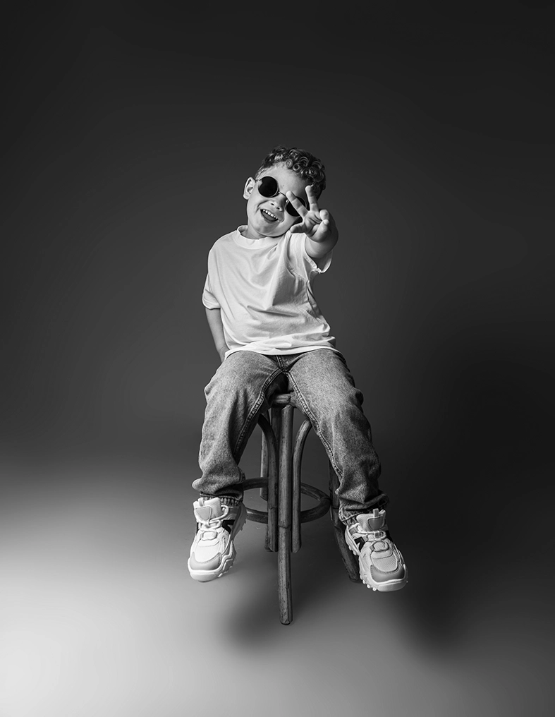 Modelo infantil Mallorca con gafas de sol posando de forma divertida en una sesión de estudio realizada por Inma del Valle.