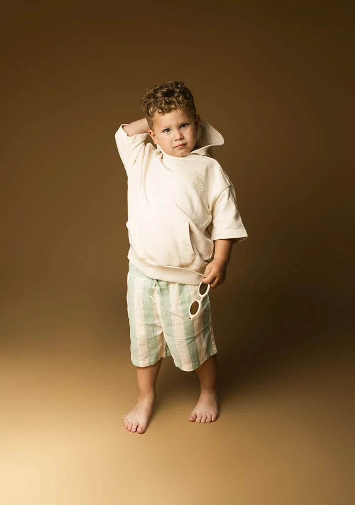 Modelo infantil Mallorca con sudadera y pantalón corto durante una sesión de estudio realizada por Inma del Valle.