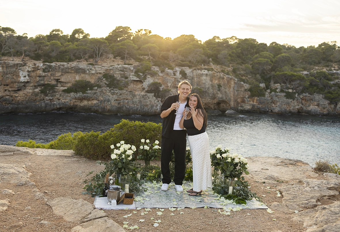 Couple toasting after their engagement at one of the best places to propose in Mallorca. Photo by Inma del Valle.