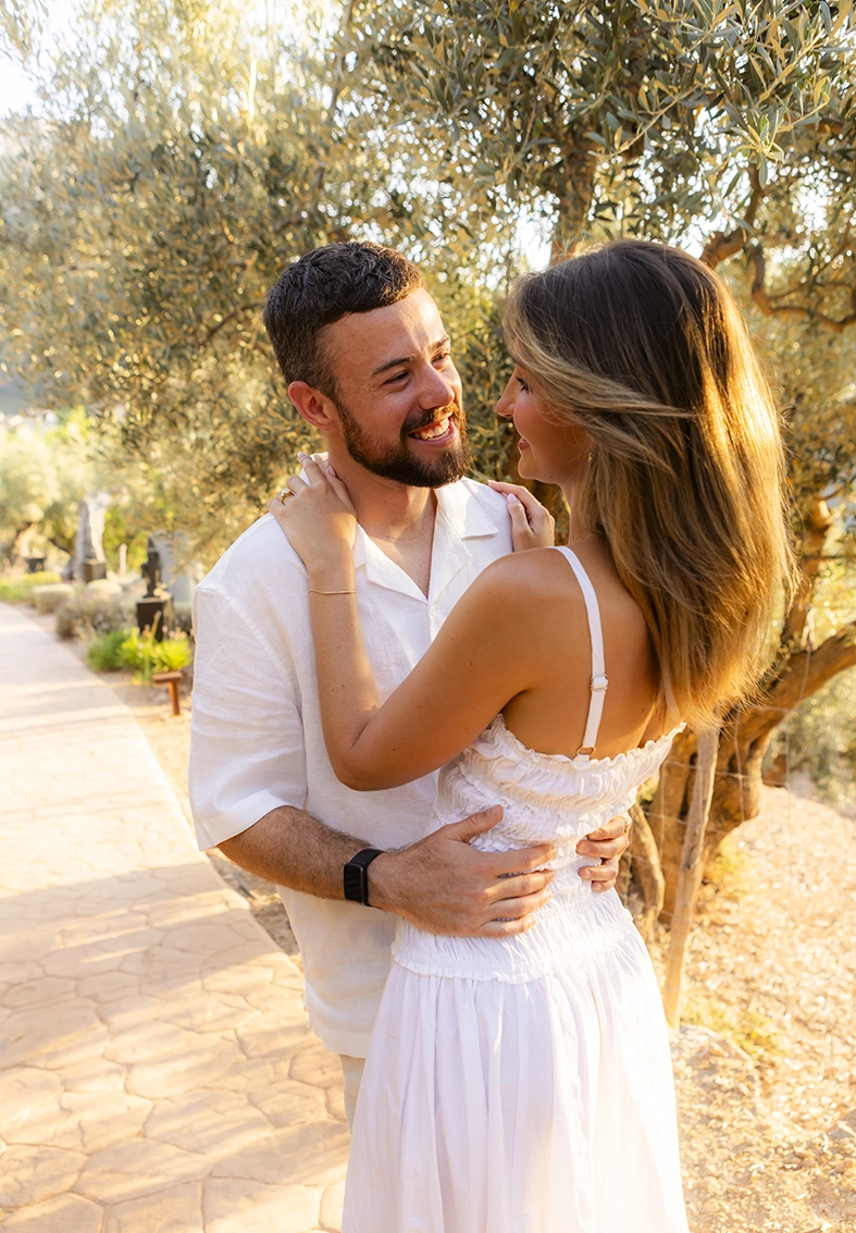 Recently engaged couple sharing a romantic moment among the olive trees at Belmond La Residencia in Deià, Mallorca.