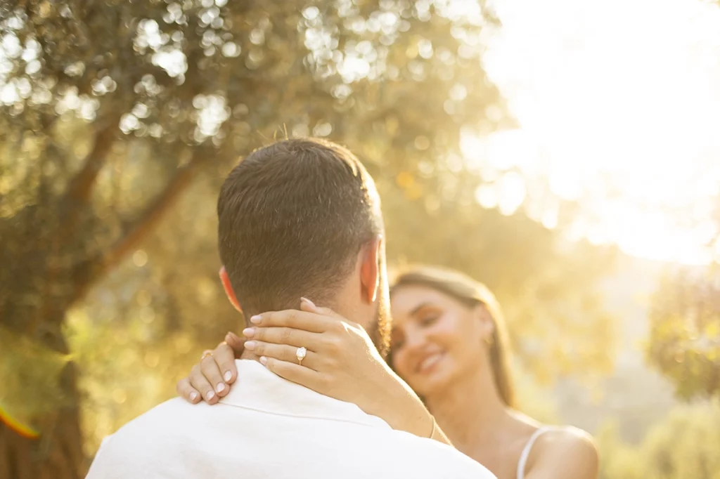 Recently engaged couple embracing in the olive gardens of Belmond La Residencia during a sunset engagement session.