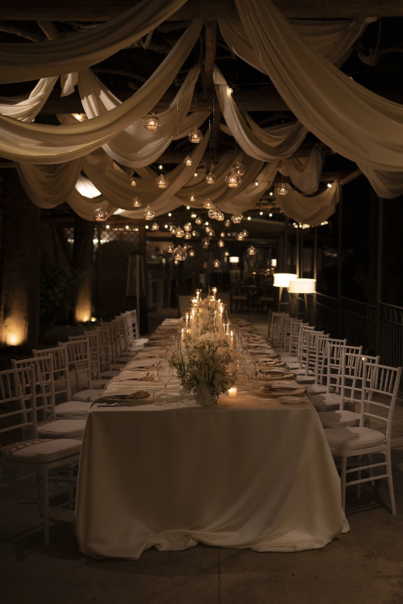 Mesa imperial decorada con velas y flores para una cena de boda en la Costa Amalfitana.