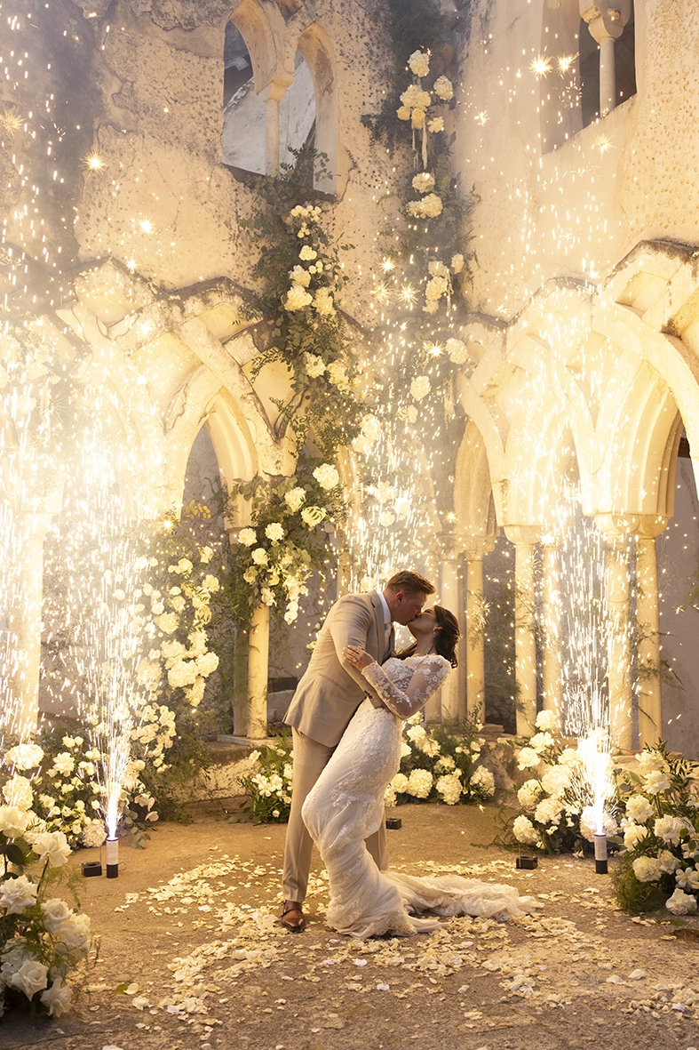 Novios durante su primer baile con fuegos fríos fotografiados por un fotógrafo de boda en la Costa Amalfitana.