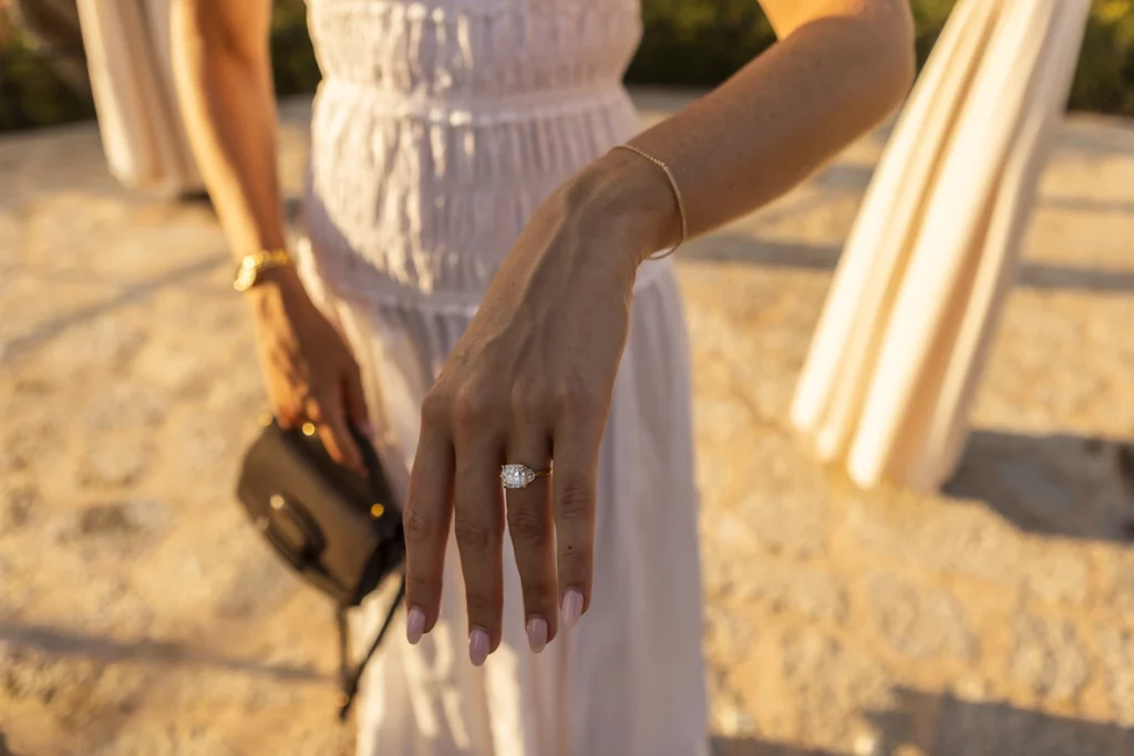 Anillo de compromiso durante una pedida de mano en Belmond La Residencia iluminado por la luz del atardecer.