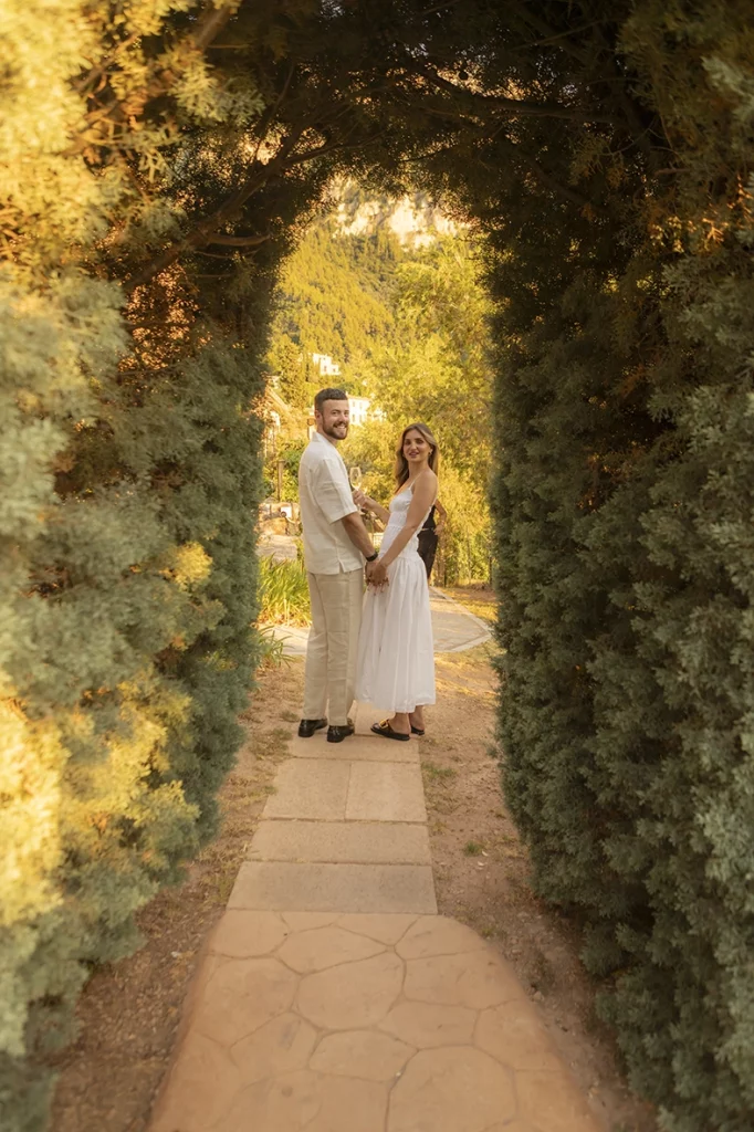 Pareja caminando de la mano por los jardines de Belmond La Residencia después de una pedida de matrimonio en Deià, Mallorca.