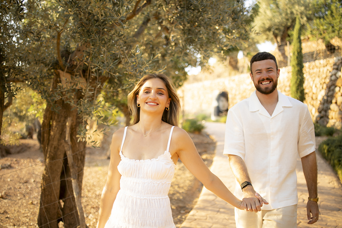 caminando de la mano entre los jardines de Belmond La Residencia después de su pedida de matrimonio en Mallorca.