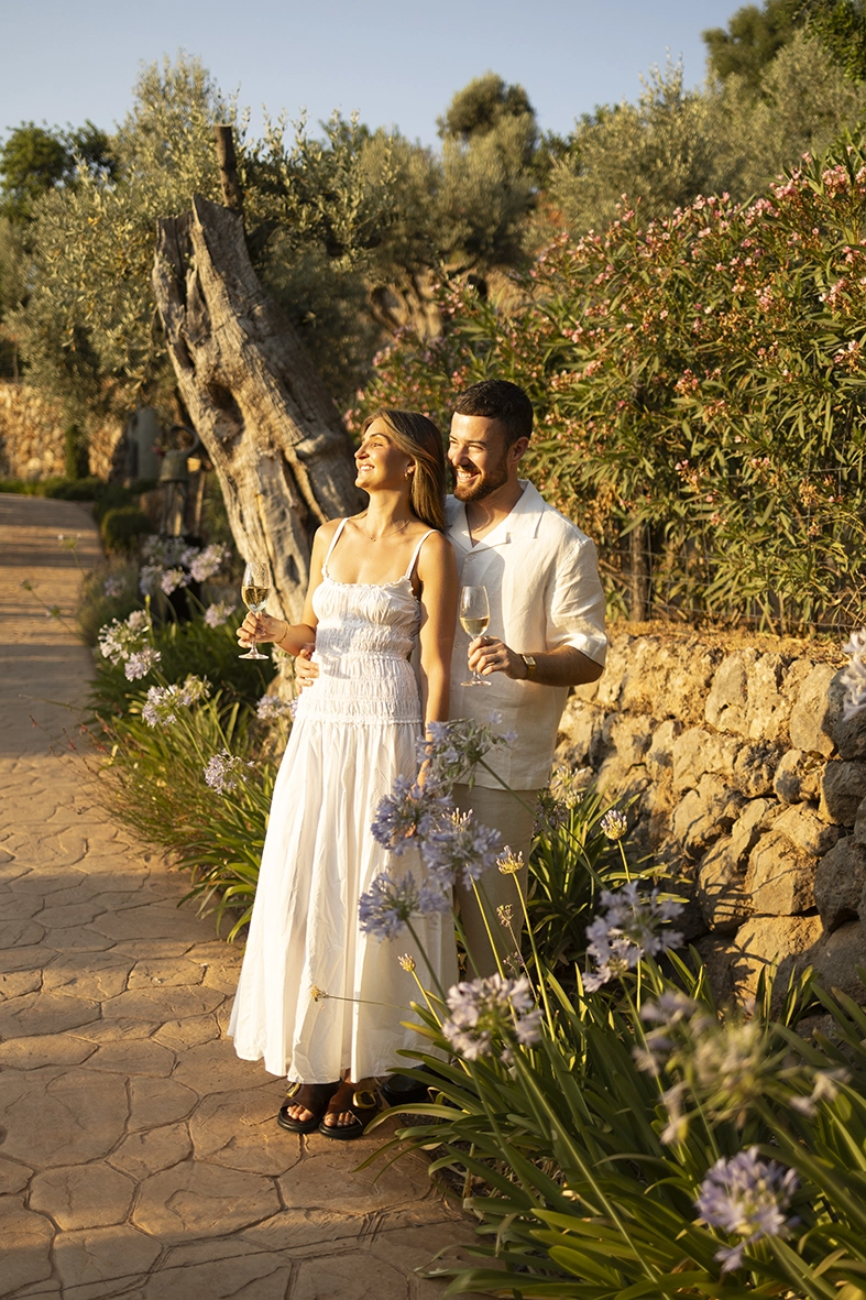 brindando con cava entre los jardines de Belmond La Residencia después de su pedida de matrimonio al atardecer.