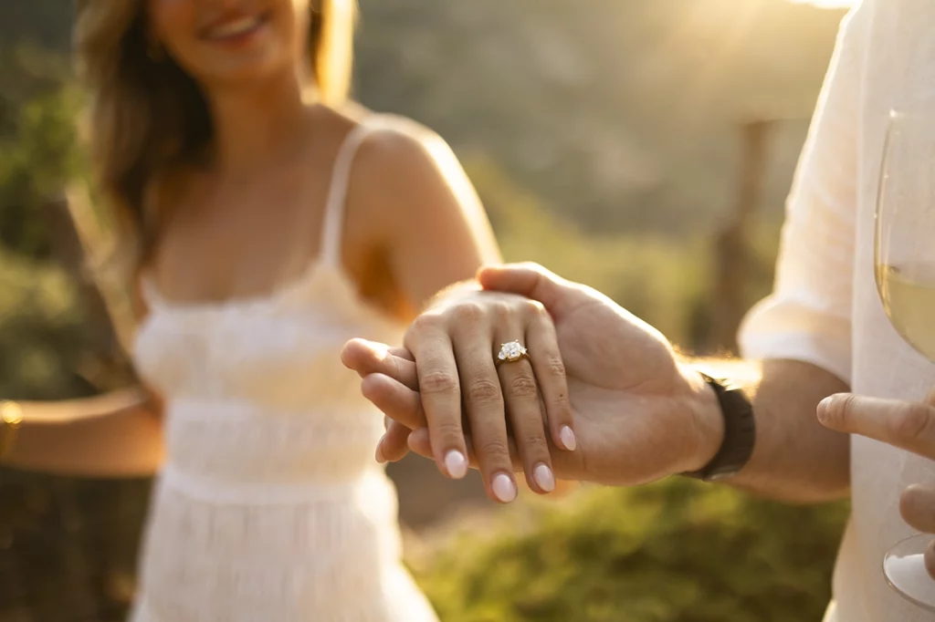 Detalle del anillo de compromiso mientras la pareja se da la mano después de la pedida en Belmond La Residencia.