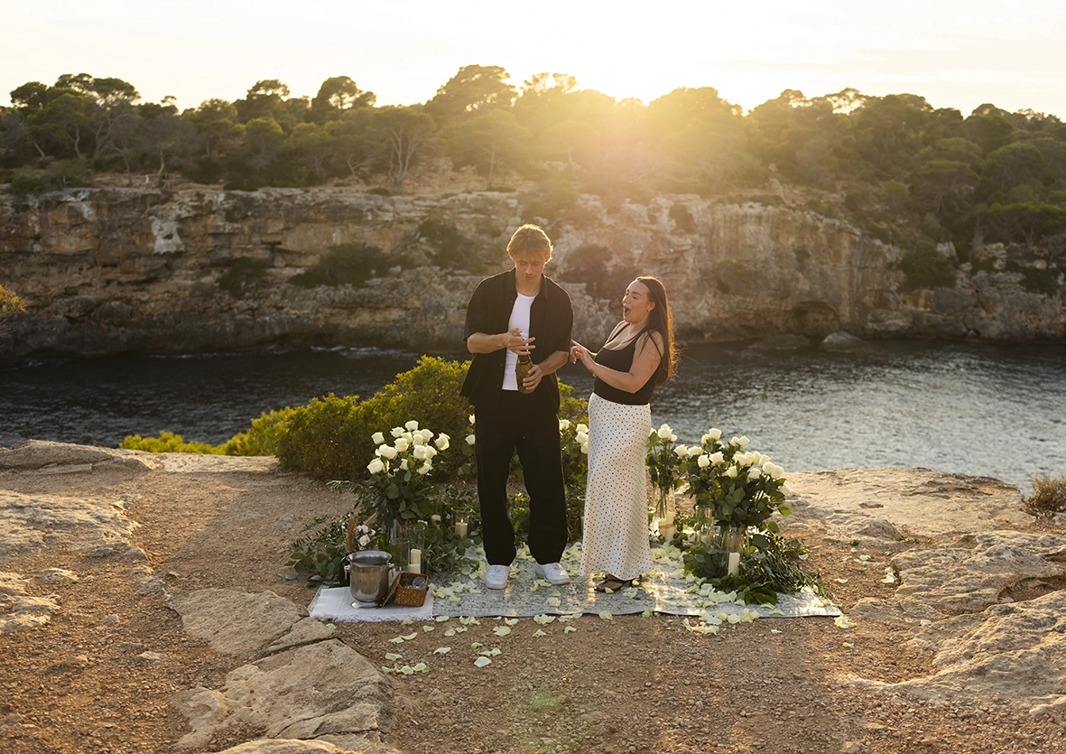 Pareja brindando con cava tras la propuesta en uno de los mejores lugares para pedida en Mallorca. Fotografía de Inma del Valle.