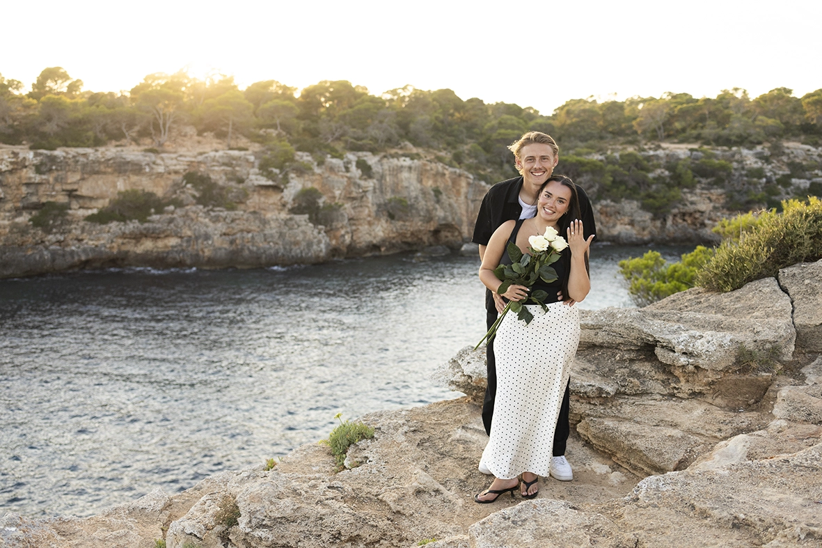 Pareja recién comprometida mostrando el anillo en uno de los mejores lugares para pedida en Mallorca. Fotografía de Inma del Valle.