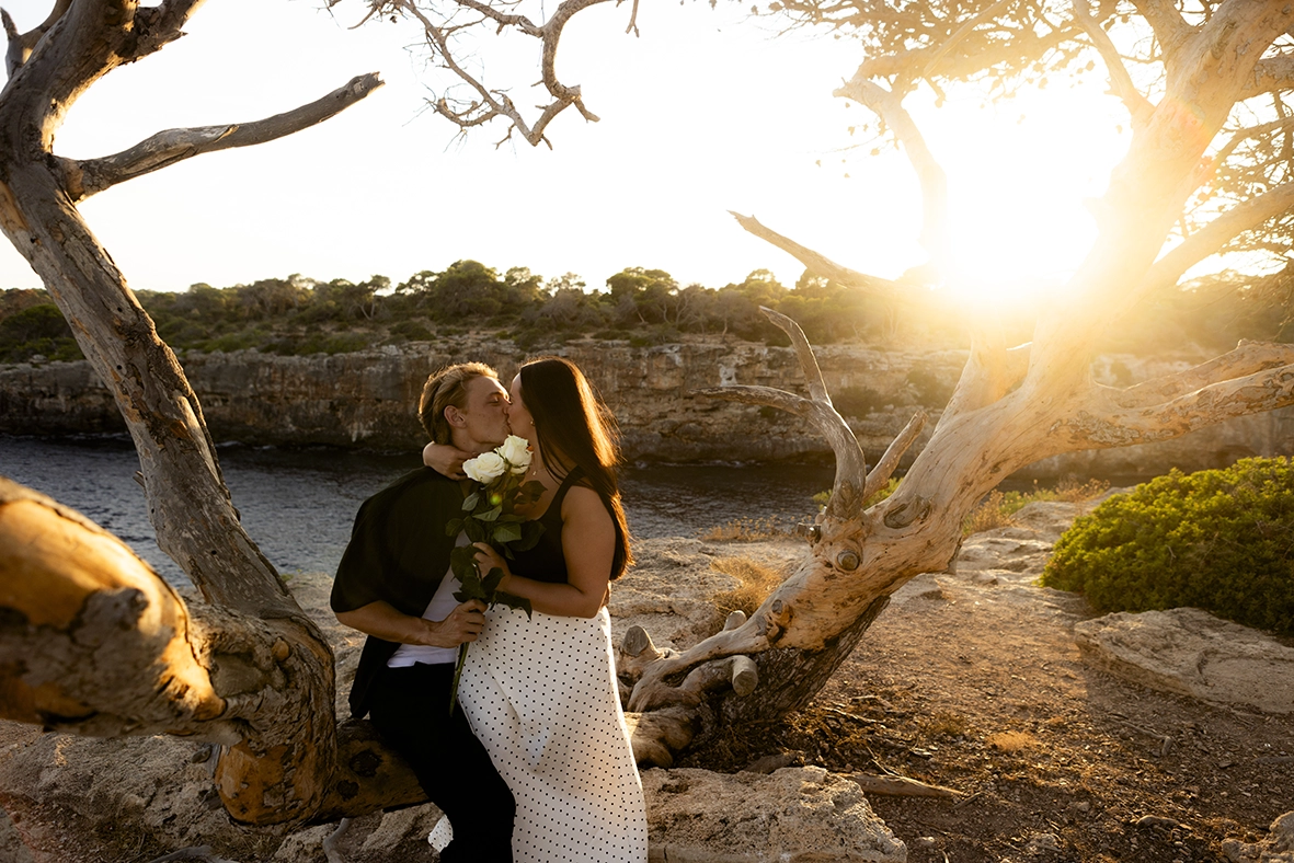 Pareja besándose bajo un árbol tras la pedida en uno de los mejores lugares para pedida en Mallorca. Fotografía de Inma del Valle.
