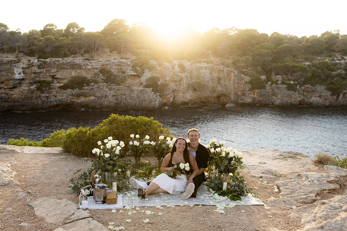 Pareja recién comprometida disfrutando del atardecer en uno de los mejores lugares para pedida en Mallorca. Fotografía de Inma del Valle.