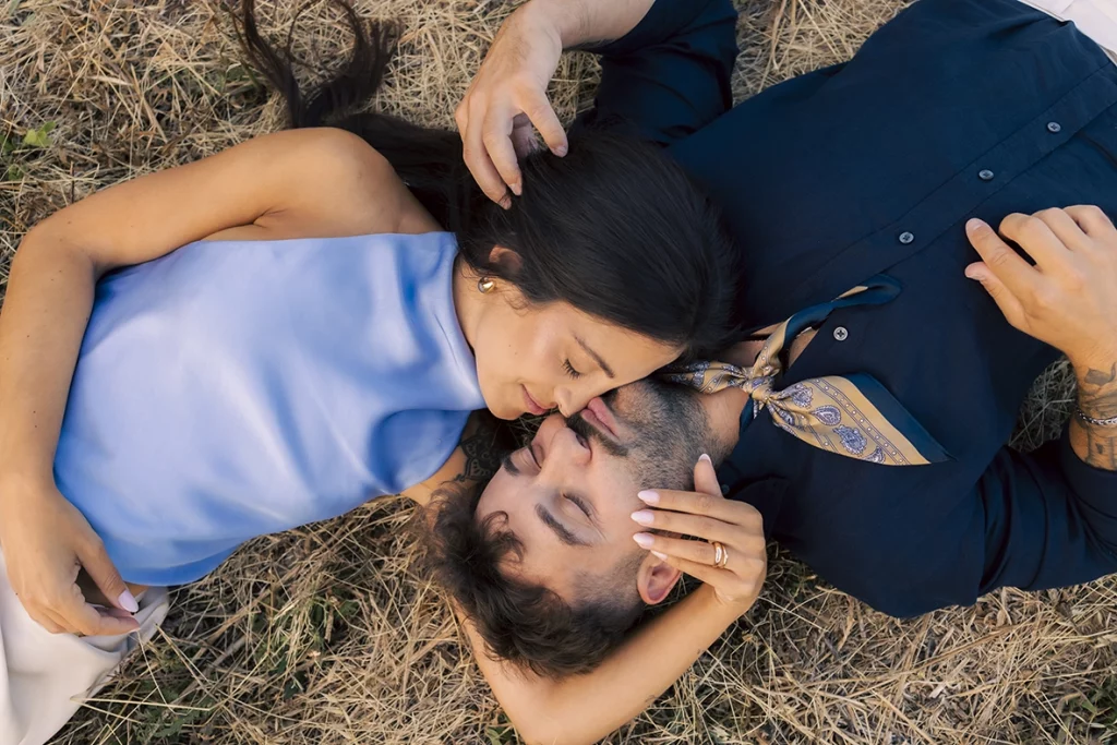 Anto and Biel lying in the grass and laughing together during their pre-wedding session in Mallorca.