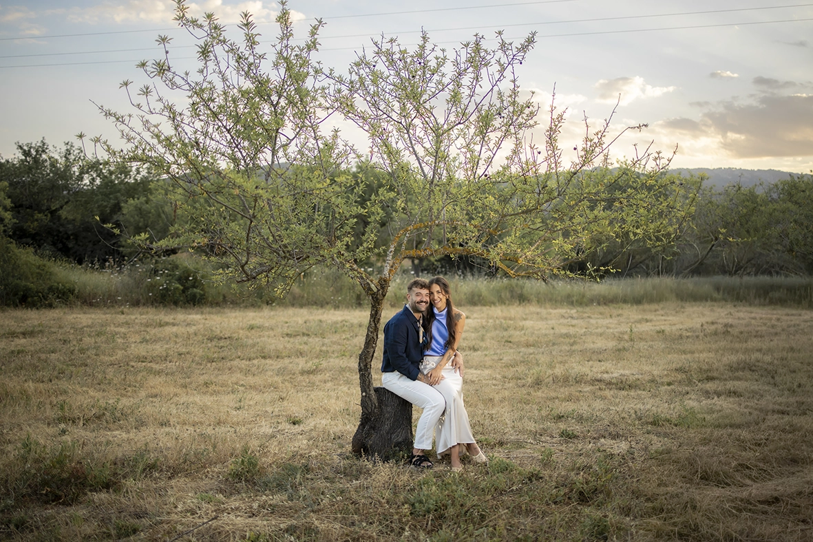 Anto and Biel sitting together in the countryside during their pre-wedding session in Mallorca.