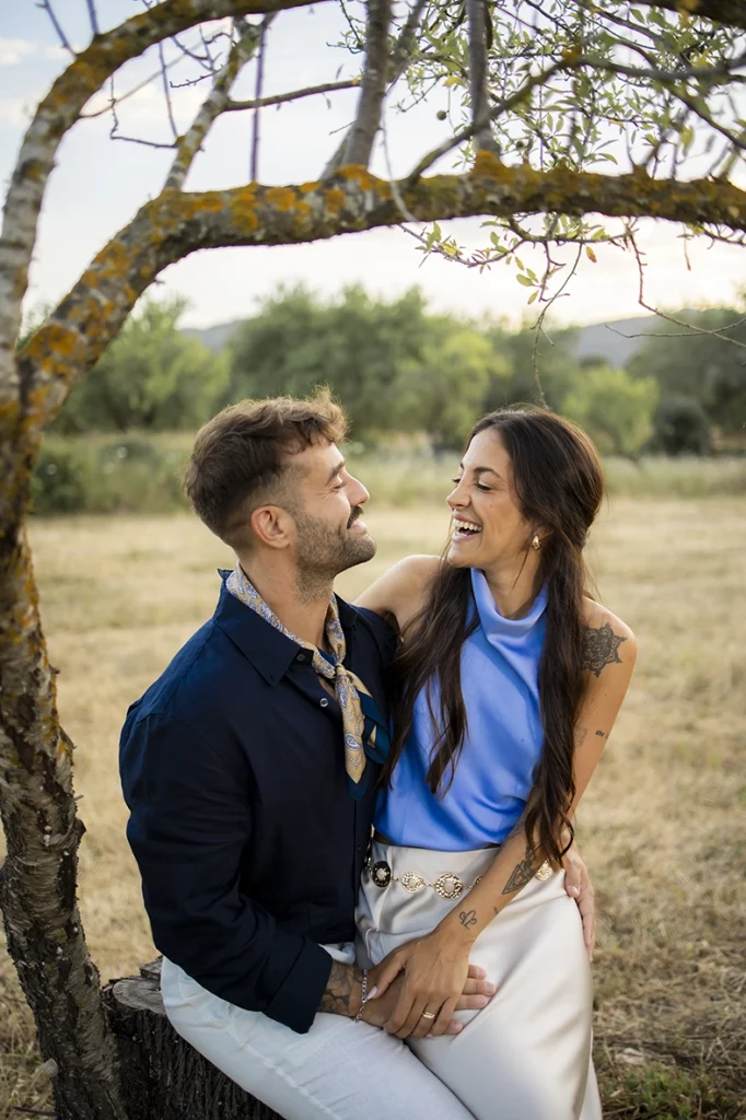 Anto and Biel sitting under a tree during their pre-wedding session in Mallorca.