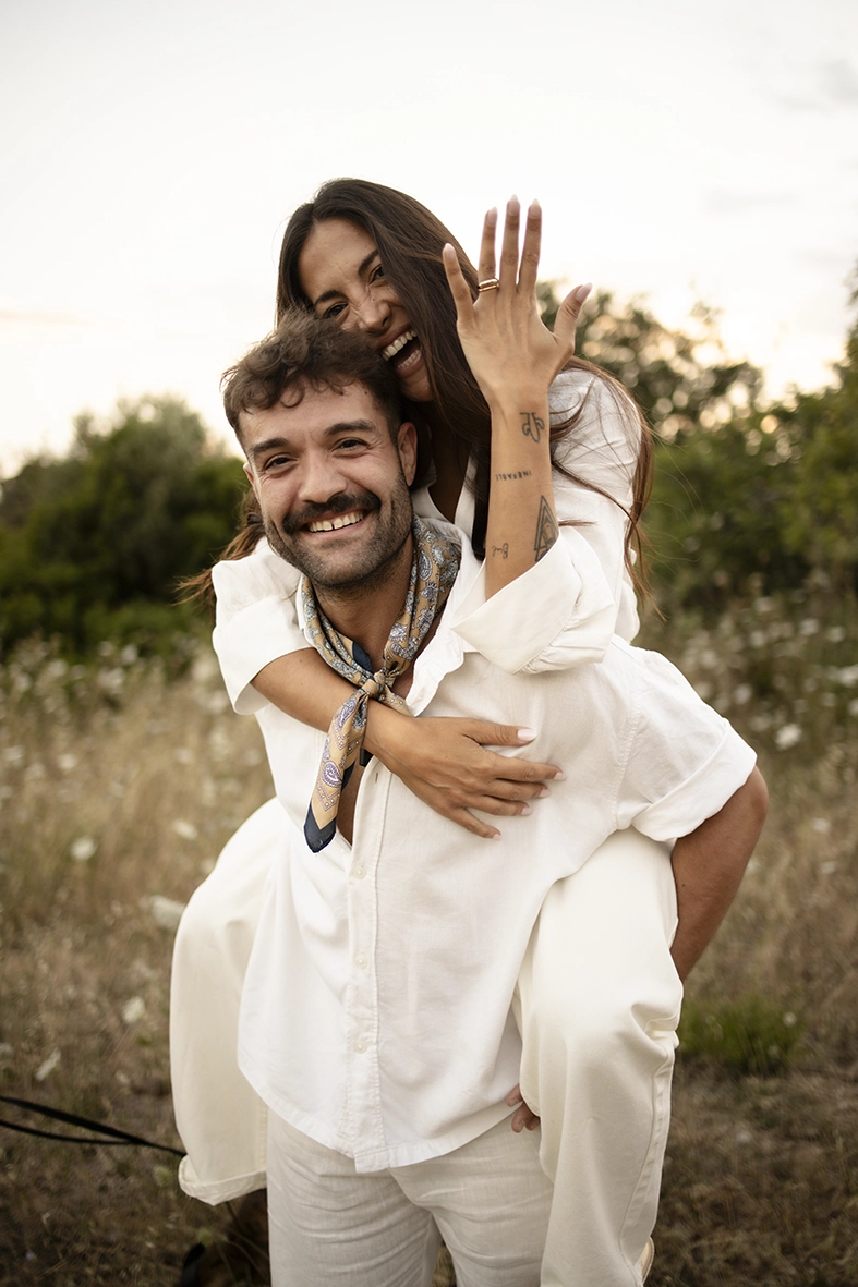 Anto riding on Biel’s back while they laugh during their pre-wedding session in Mallorca.