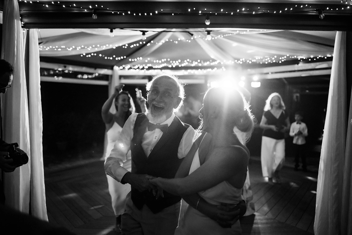Black-and-white photograph of wedding guests dancing together during an evening reception on the Amalfi Coast.