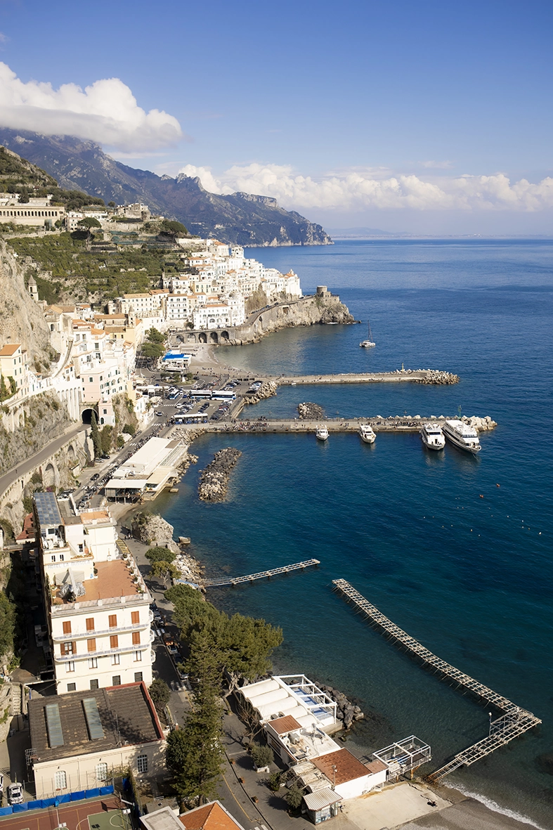 Panoramic view of Amalfi, its harbour, cliffs and the blue Mediterranean Sea.