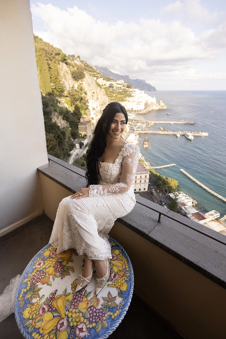 Bride sitting on a balcony overlooking the Mediterranean, photographed by a wedding photographer on the Amalfi Coast.