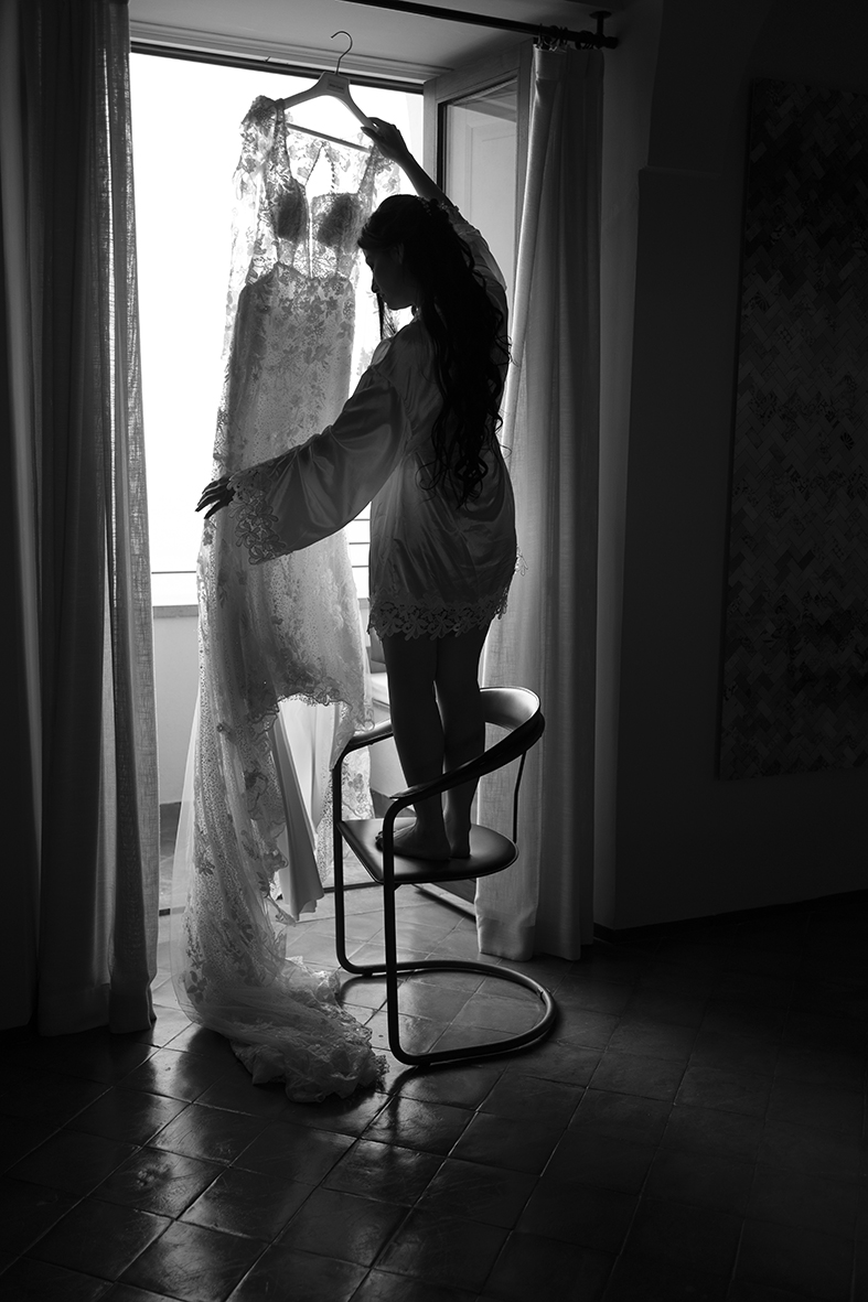 Bride getting ready beside a window before her wedding on the Amalfi Coast.